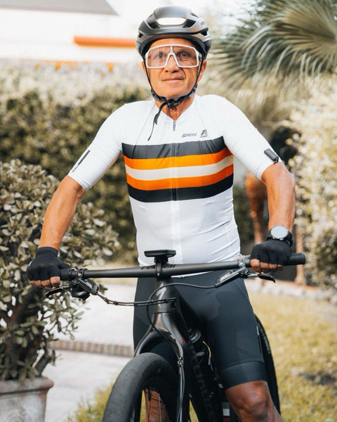 Cyclist in a striped jersey and helmet on a mountain bike